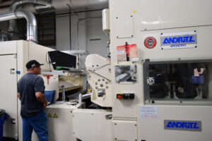 Operator inspects nonwoven material as it emerges from the needleloom in NWI's Staple Nonwovens Pilot Lab.