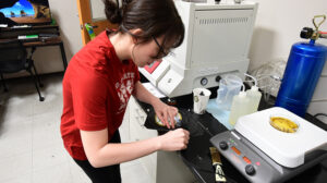 A researcher prepares a facemask for testing in NWI's Filtration Testing Lab.