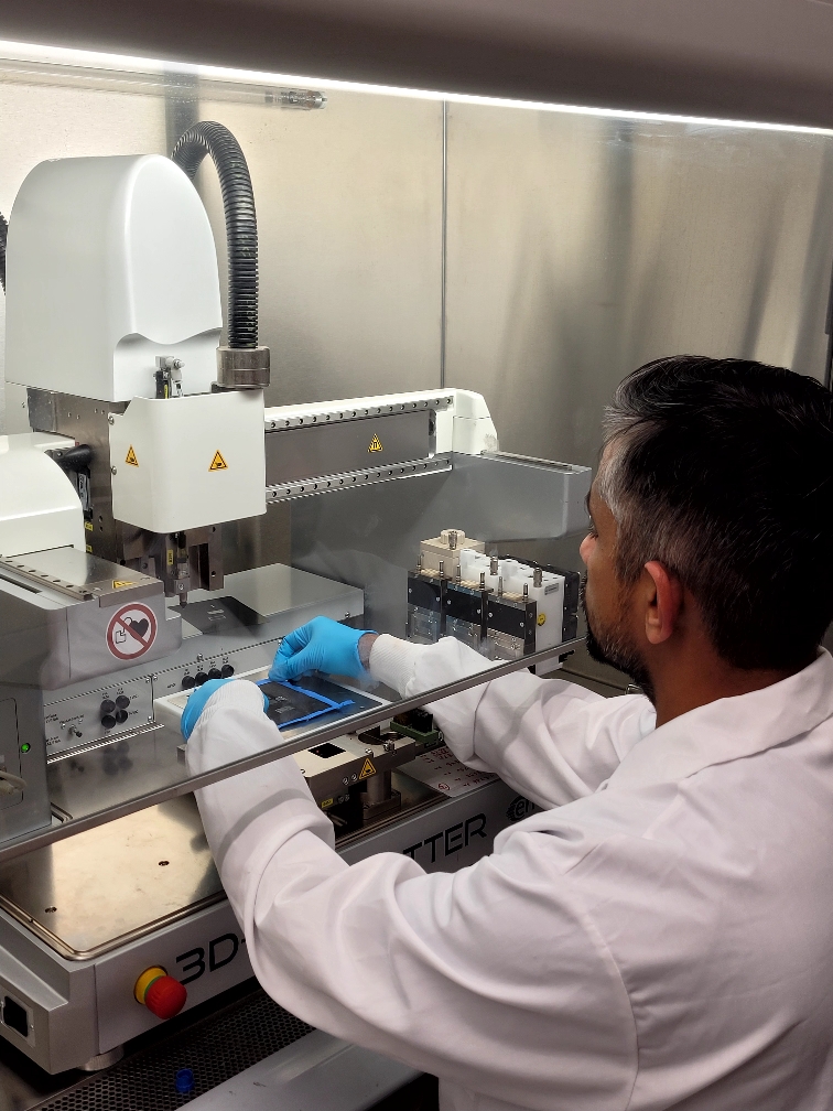 Sreenivasan placing a nonwoven sample on the platform of a 3D bioplotter printer