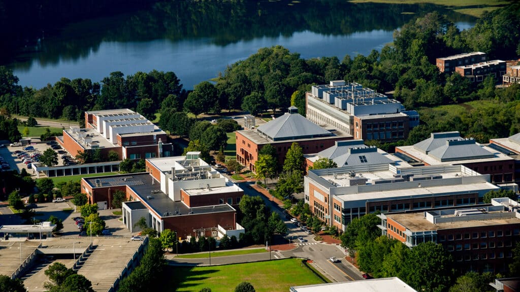 Centennial Campus buildings including the Monteith Research Center (right) and the Wilson College of Textiles (center) look out onto Lake Raleigh. Photo by Becky Kirkland.